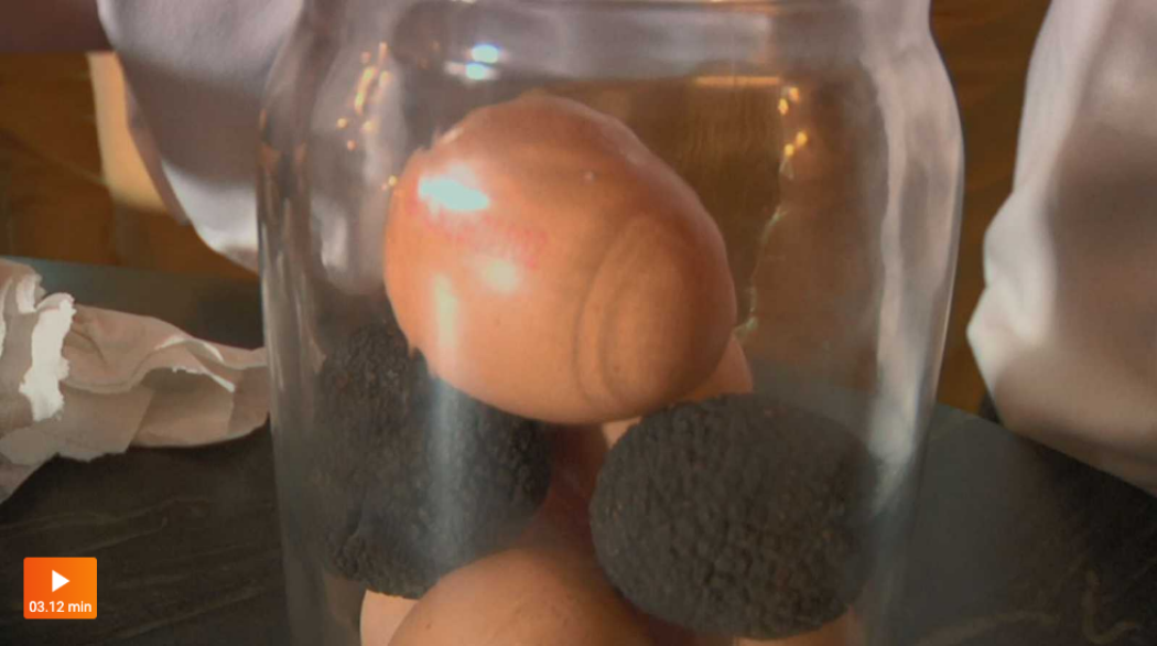 Bote de cristal que contiene trufas y huevos enteros