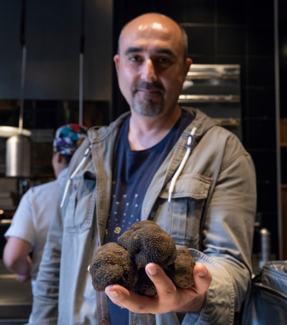 Javier Acedo avec une grosse truffe noire dans sa main.